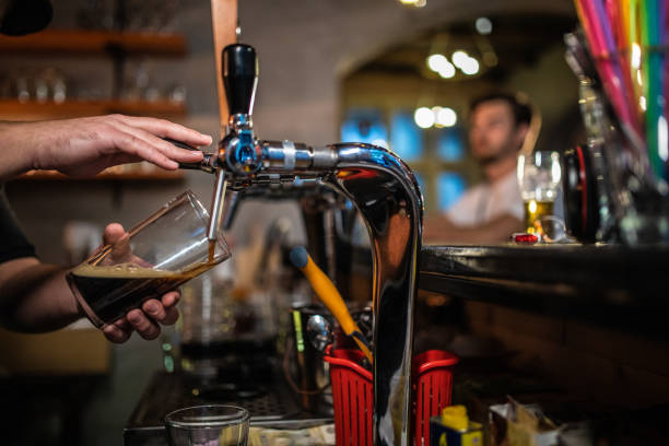 istock Bartender Pouring Glass of Beer 1055939526