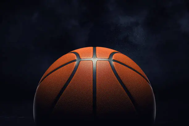 Photo of 3d rendering of an orange rubber surface of a basketball ball shown on a black background.