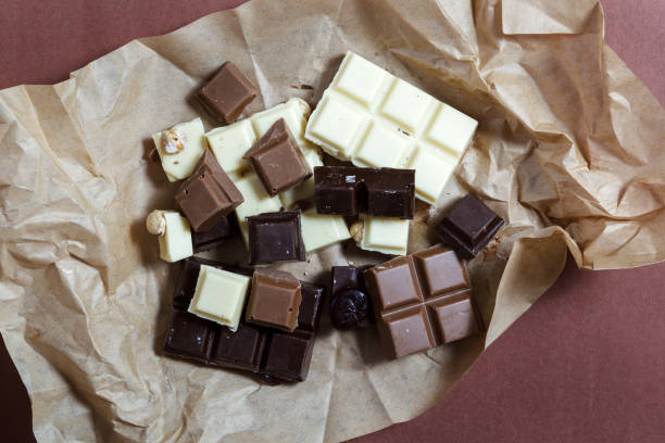 istock Dark, milk and white chocolate on brown paper. 1055947762