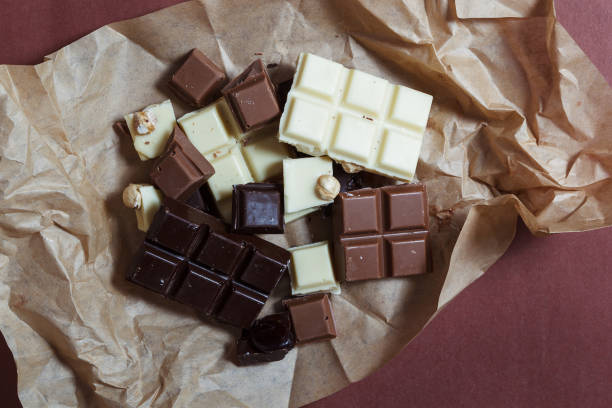 istock Dark, milk and white chocolate on brown paper. 1055948324