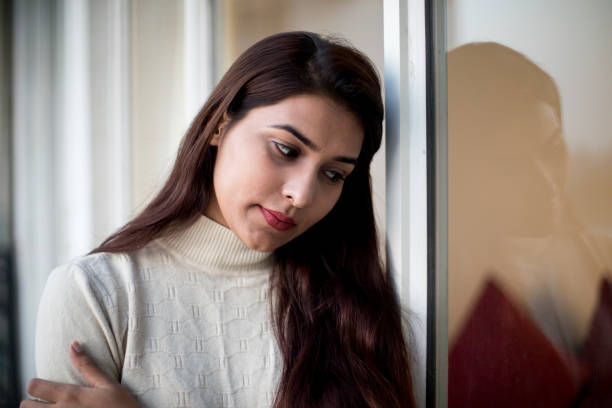 Worried young woman with head in hands