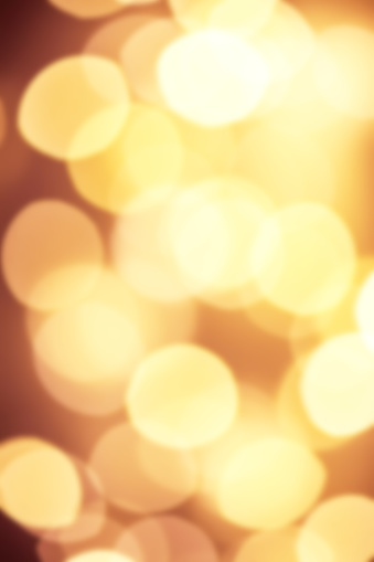 Goldn  Lights Festive background. Abstract Christmas twinkled bright background with bokeh defocused yellow lights