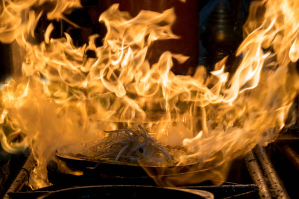 close-up movimento mão a pá de frigideira, cozinhar a deliciosa comida tailandesa tradicional de fritar casca de ostras em uma panela com o fogo, cozinhar e alimento conceito, - pan frying pan fire fried - fotografias e filmes do acervo