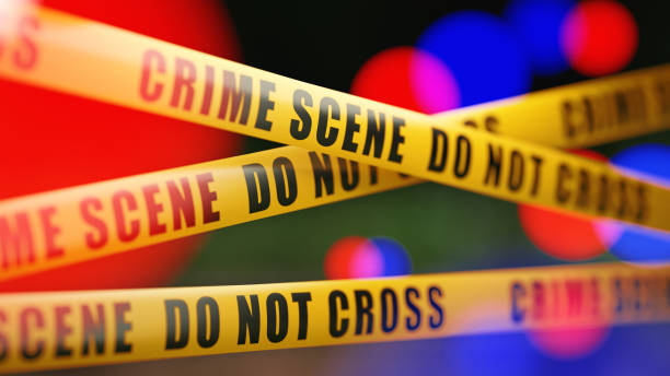 istock Crime Scene Tape Barrier In Front Of Defocused Lights 1055959612