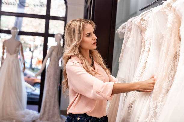 istock Attractive young woman looking at the dresses 1055961634