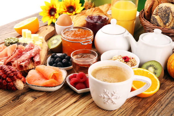 istock breakfast on table with bread buns, croissants, coffe and juice. 1055962786