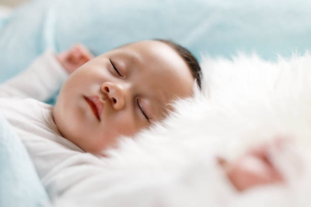 Baby sleeping in bed stock photo