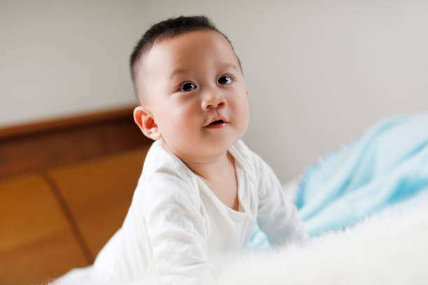 istock Cute baby on the white bed 1055964616