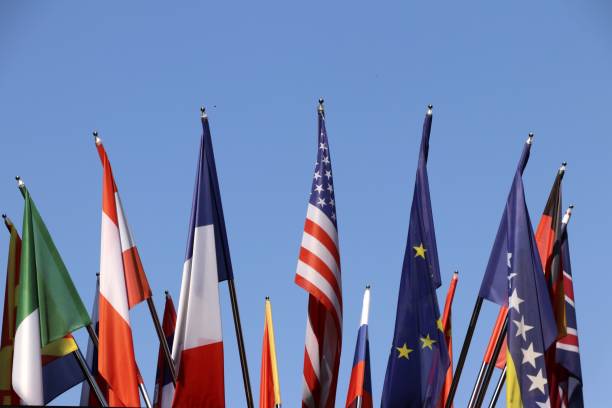istock Group of the flags of various contries outside under blue sky 1055965310