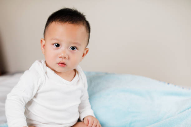 istock Cute baby on the white bed 1055965530