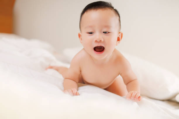 istock Cute baby on the white bed 1055966684