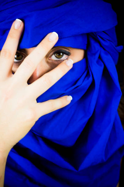 istock Beautiful woman with blue trub on black background 1055966776