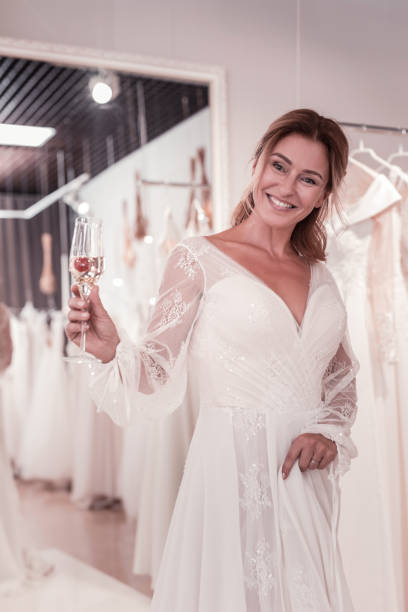 istock Happy delighted bride holding a glass with champagne 1055968178