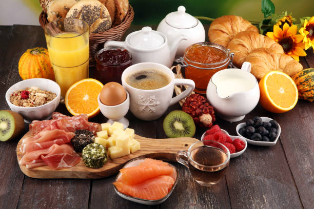 istock breakfast on table with bread buns, croissants, coffe and juice. 1055973792