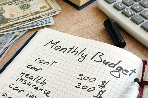 Note pad con cálculos de presupuesto mensual y el dinero. photo