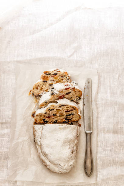istock Traditional German Christmas fruit cake shtalen on bright linen tablecloth. View from above,flat lay, copy space 1055977342
