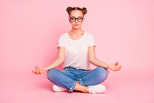 Time to rest and relax! Serenity and silence concept. Full legs, body, size portrait of cute and sweet pacified meditating girl folding fingers in mudra isolated on vivid pink background