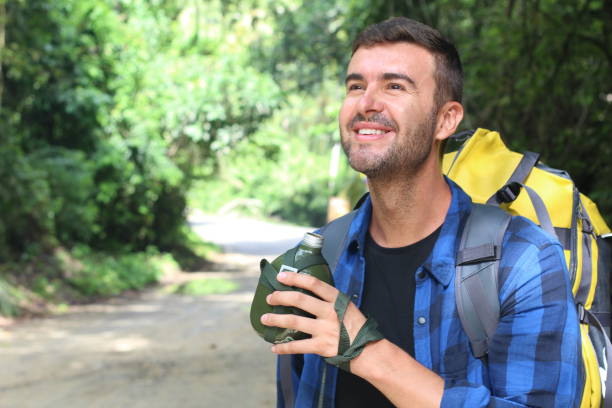istock Backpacker holding water metallic canteen with copy space 1055983034