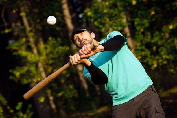 playing baseball sport The baseball player is playing baseball as recreation in park in nature. baseball hitter stock pictures, royalty-free photos & images