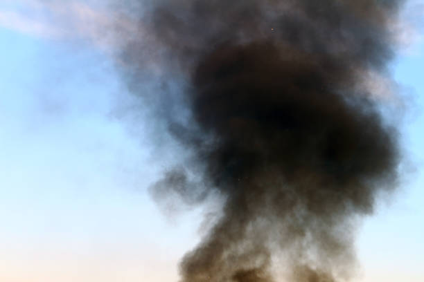 istock heavy smoke pillar on the day sky background. 1055992234