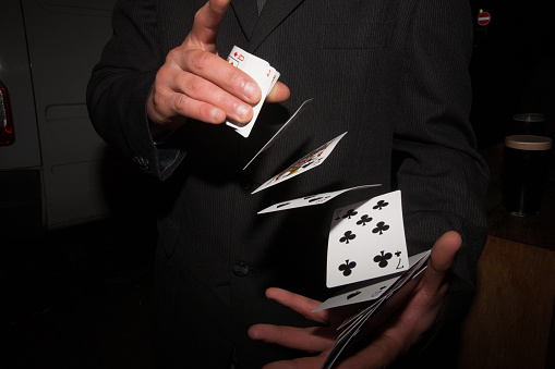 A magician shuffling a deck of playing cards