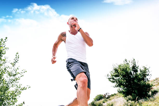 young and sporty man jogging outdoors in a park, wearing shorts