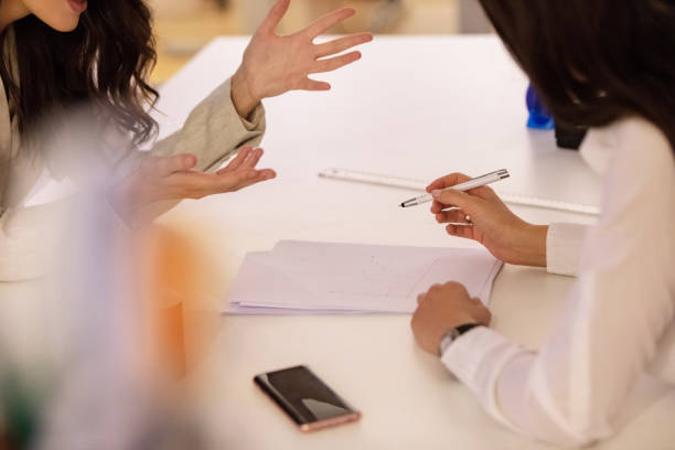 istock Businesswomen gesturing at a meeting 1056003736