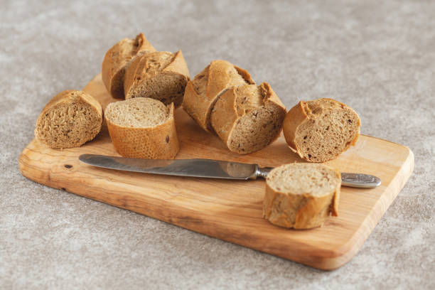 istock Fresh sliced rye baguette on the wooden cutting board. Horizontal view 1056007418