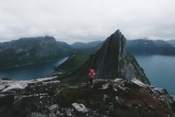 istock Man with dog and backpack hiking to Segla mountain in Norway 1056012242