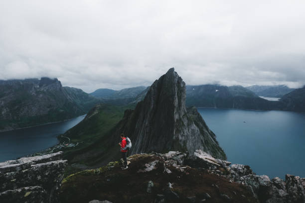 istock Man with dog and backpack hiking to Segla mountain in Norway 1056012260