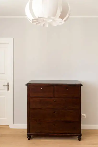 Restored dark brown commode in a modern minimalistic interior.