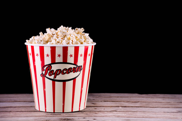 istock Popcorn in full retro box on wooden rustic desk 1056018648