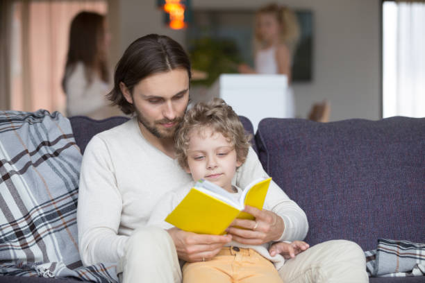 istock Father and son with fairytale book on couch 1056019182