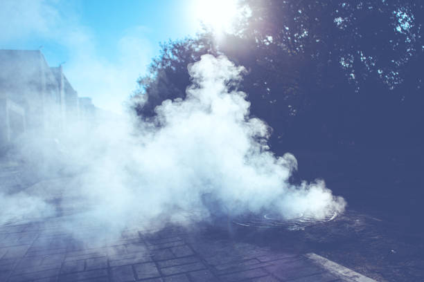 istock Accident on the heating line under the ground - thick steam from under the sewer manhole 1056019456