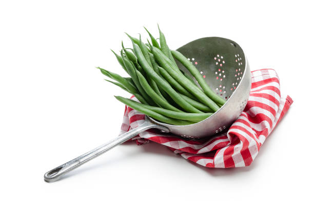 Fresh organic green beans bunch in an old metal colander isolated on white backdrop. The colander is placed on a red and white checkered tablecloth. Useful copy space left for text and/or logo. Predominant colors are green, red and white. High key DSRL studio photo taken with Canon EOS 5D Mk II and Canon EF 100mm f/2.8L Macro IS USM.