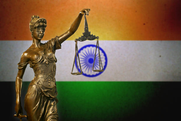 Lady Justice before an Indian flag Close-up of a small bronze statuette of Lady Justice before an Indian flag. lawyer india stock pictures, royalty-free photos & images