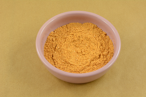 Taco spice seasoning mix ingredient in pink condiment bowl on parchment paper on table
