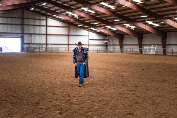 istock Senior cowboy at indoor rodeo practicing arena 1056033002
