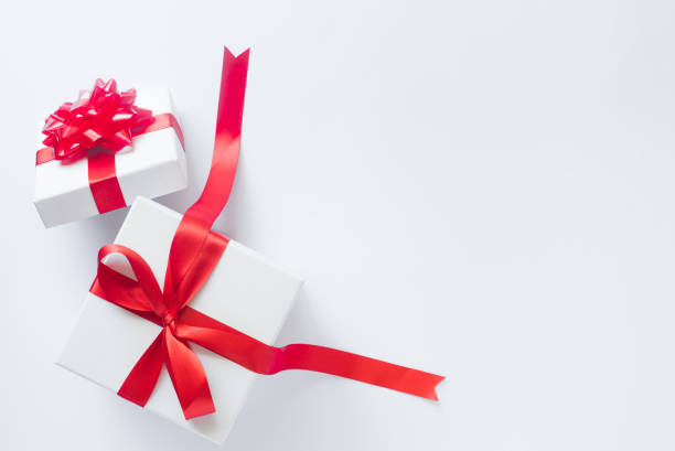 istock White gift box with red satin bow and ribbon on white background with copy space 1056035758