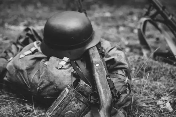 Photo of German Military Ammunition Of World War Ii On Ground. Military Helmet, Lights, Rifle. Photo In Black And White Colors