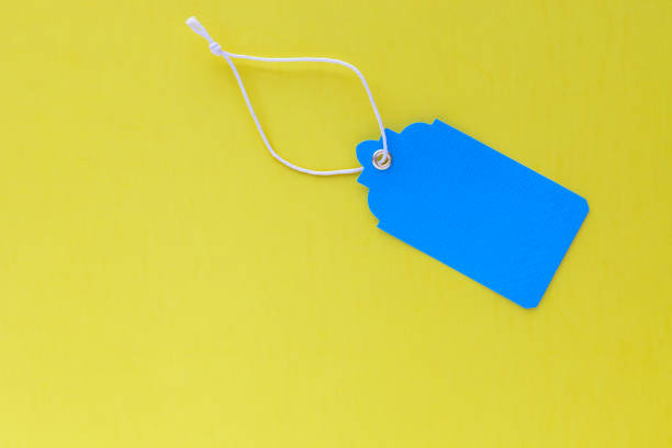 istock Blank blue sale tag mock up isolated on bright yellow background 1056037620