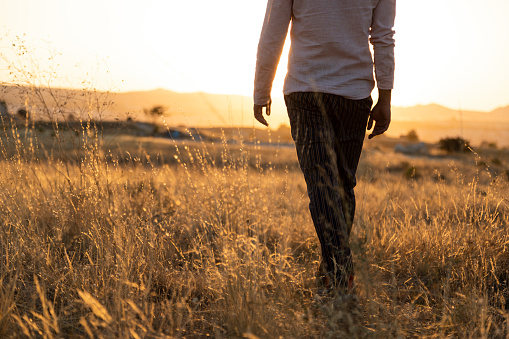 Young man walking in the countryside while sundown ,outside shoot