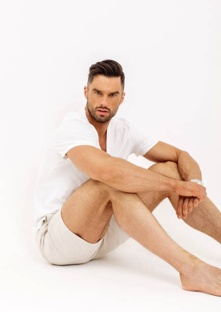 istock Handsome man wear summer clothes and sitting, isolated on white background 1056038172