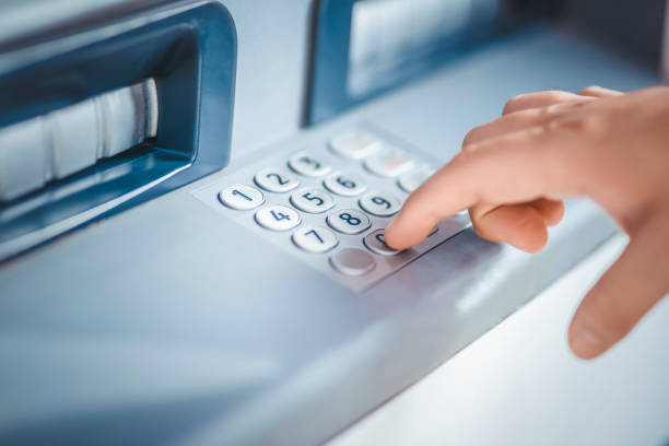 Woman using ATM machine to withdraw money stock photo