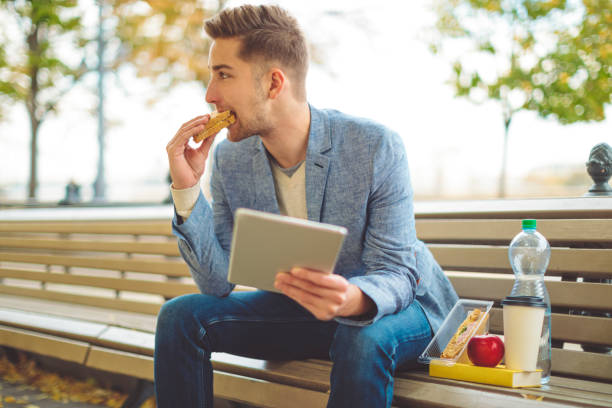 istock Young man having lunch outdoors 1056044672