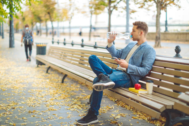 istock Young man having lunch outdoors 1056045384