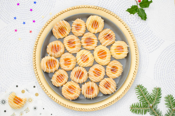 Czech Kolache Cookies Top view of a homemade cream cheese Kolache cookies filled with apricot and glazed in a golden plate and served on a festive table for a Christmas holiday menu kolache stock pictures, royalty-free photos & images