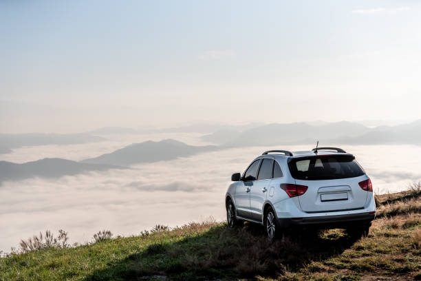 夕日に雲と山の頂上で suv 車。 - car mount ストックフォトと画像