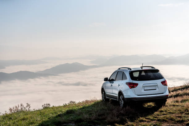 일몰에 구름으로 산 꼭대기에서 suv 차량. - car mount 뉴스 사진 이미지