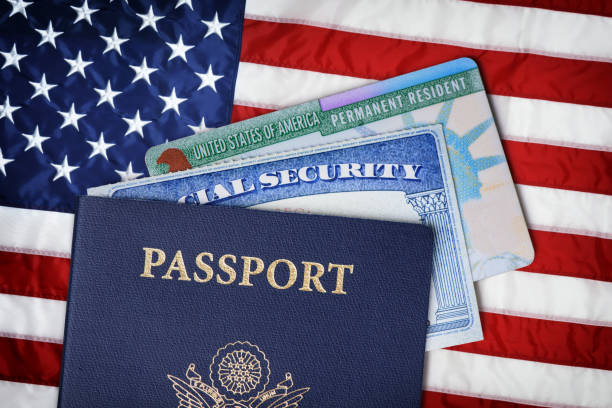 estados unidos passaporte, cartão da segurança social e cartão de residente sobre a bandeira americana. conceito de imigração - passaporte e visto - fotografias e filmes do acervo